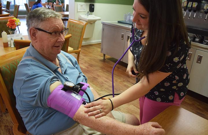 An Assisted Living resident gets his blood pressure checked