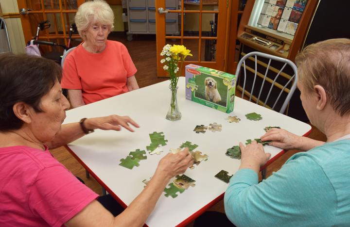 Memory Care residents enjoy a puzzle