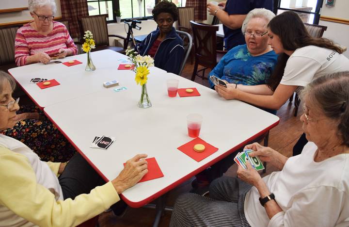Memory Care residents enjoy a round of UNO
