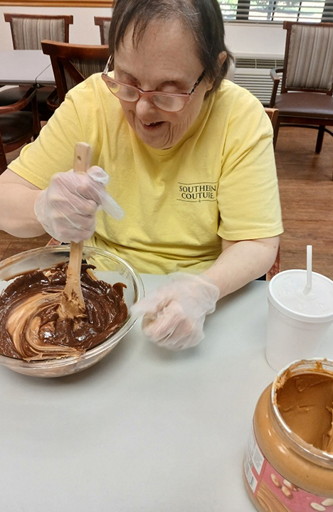 A Memory Care resident enjoys some cooking time