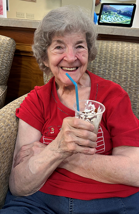 A Memory Care resident enjoys a milkshake