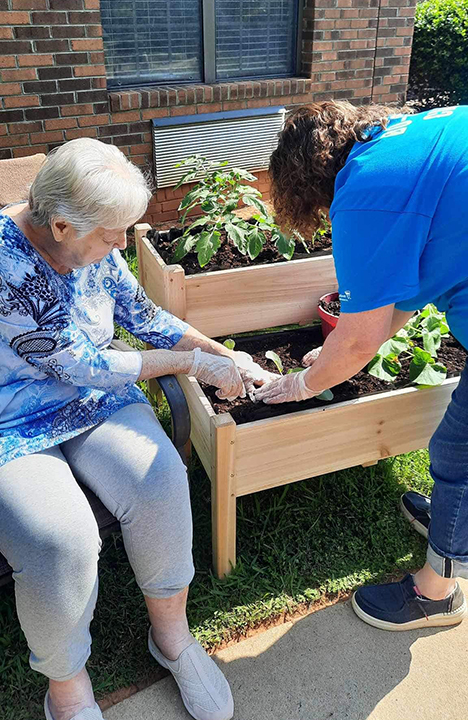 A Memory Care resident enjoys some gardening