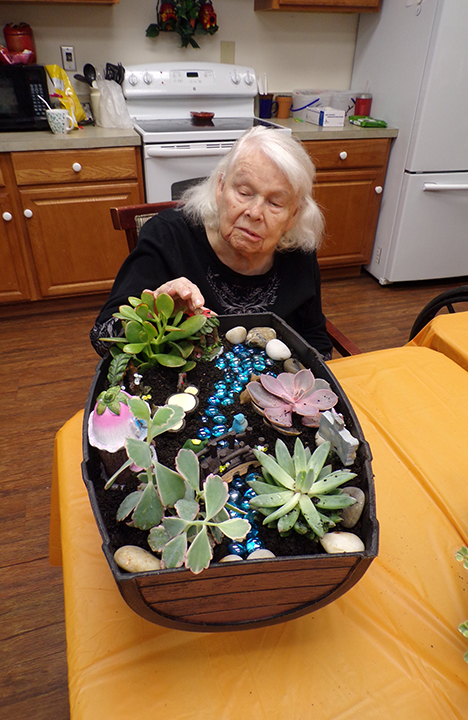 A Memory Care resident making a fairy garden