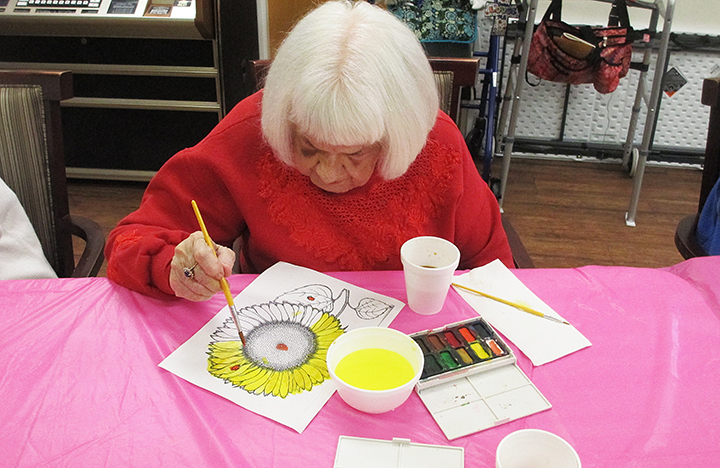 A Memory Care resident enjoying painting