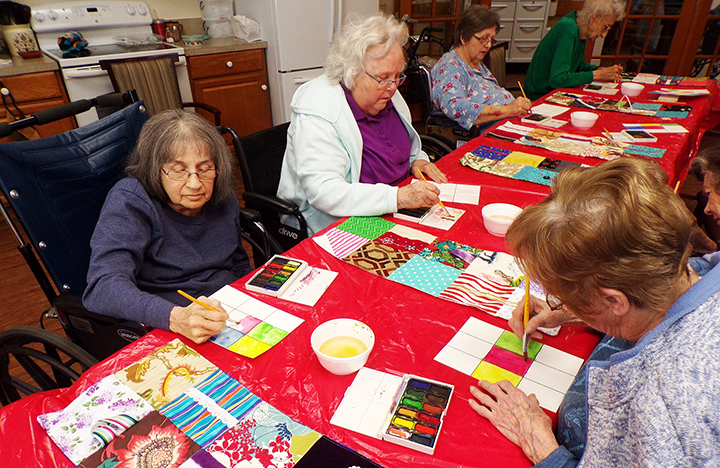 Memory Care residents making paper quilts