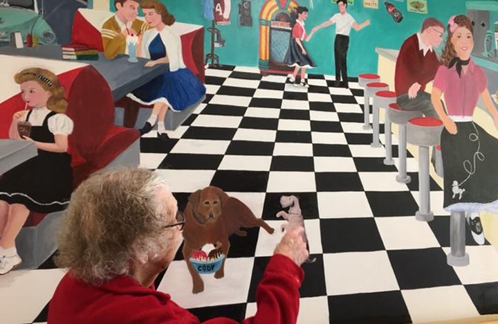 A Memory Care resident enjoys looking at one of the many murals in the Care Center
